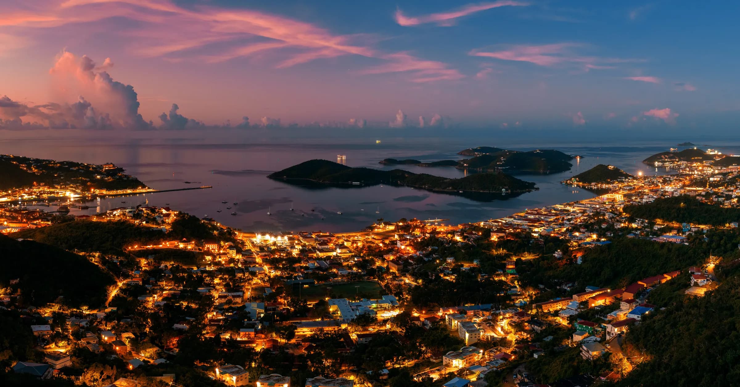 Representative imagery for The Banana Deck: Charlotte Amalie hillsides and harbor glowing at twilight on St. Thomas. Not a photograph of this listing.