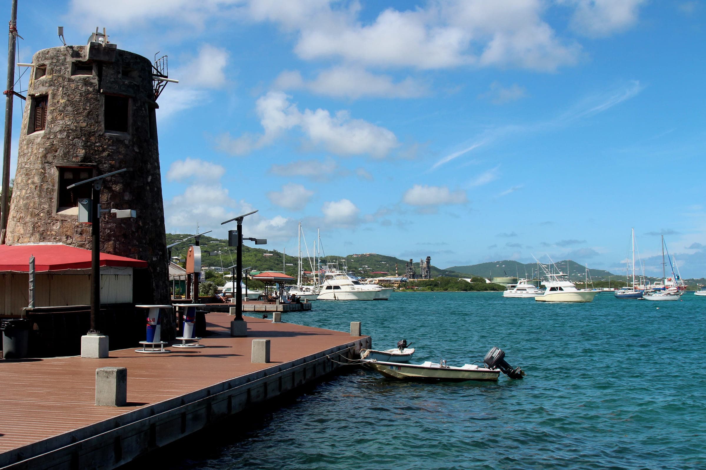 The red waterfront boardwalk at Christiansted on St. Croix, running past the historic stone tower to the harbour anchorage, photographed in 2015.