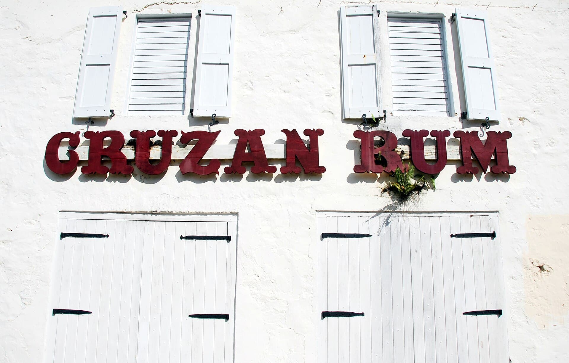 The Cruzan Rum sign across the white distillery facade at Estate Diamond, St. Croix.