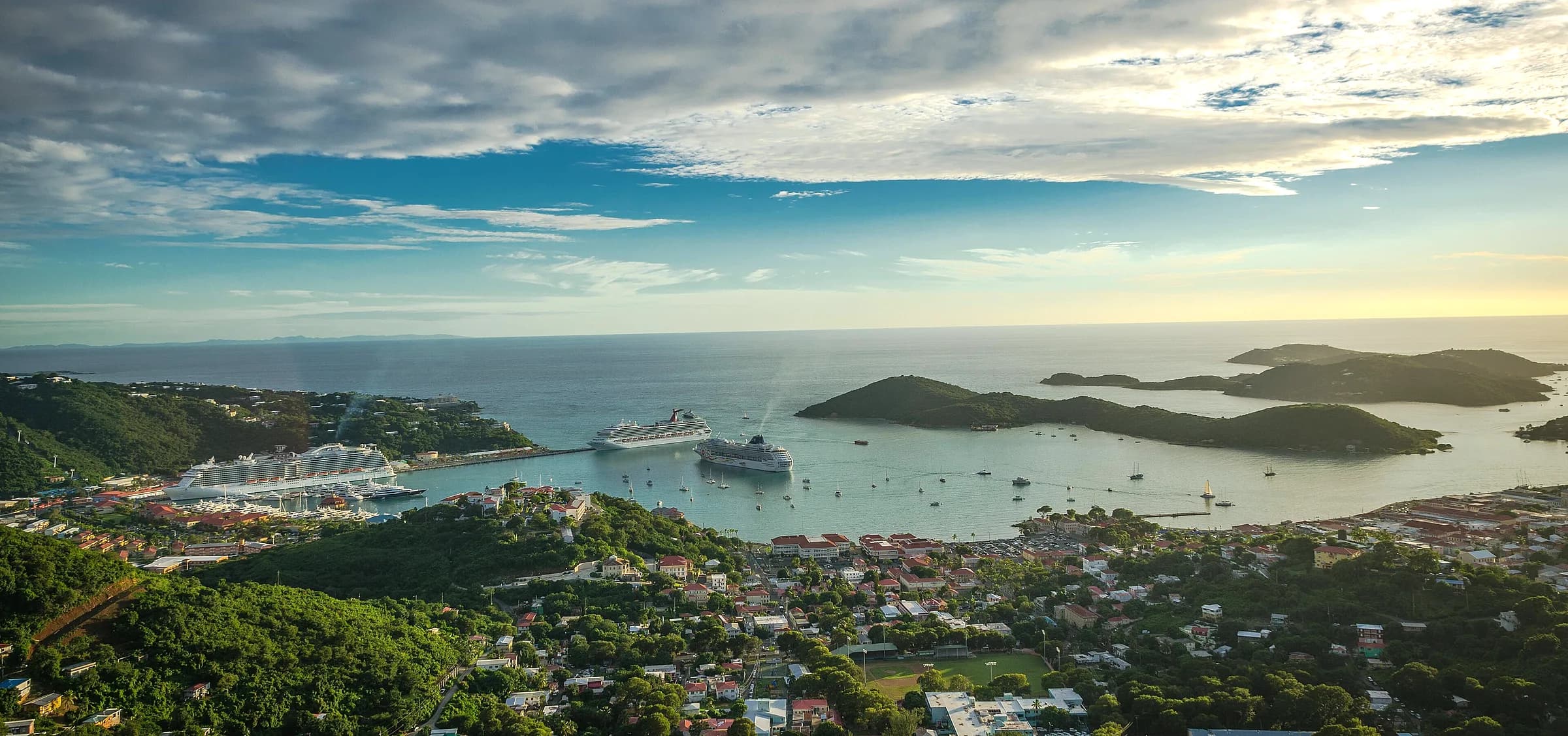 Panoramic view of Charlotte Amalie harbor in St. Thomas with cruise ships, islands, hills, and open Caribbean water