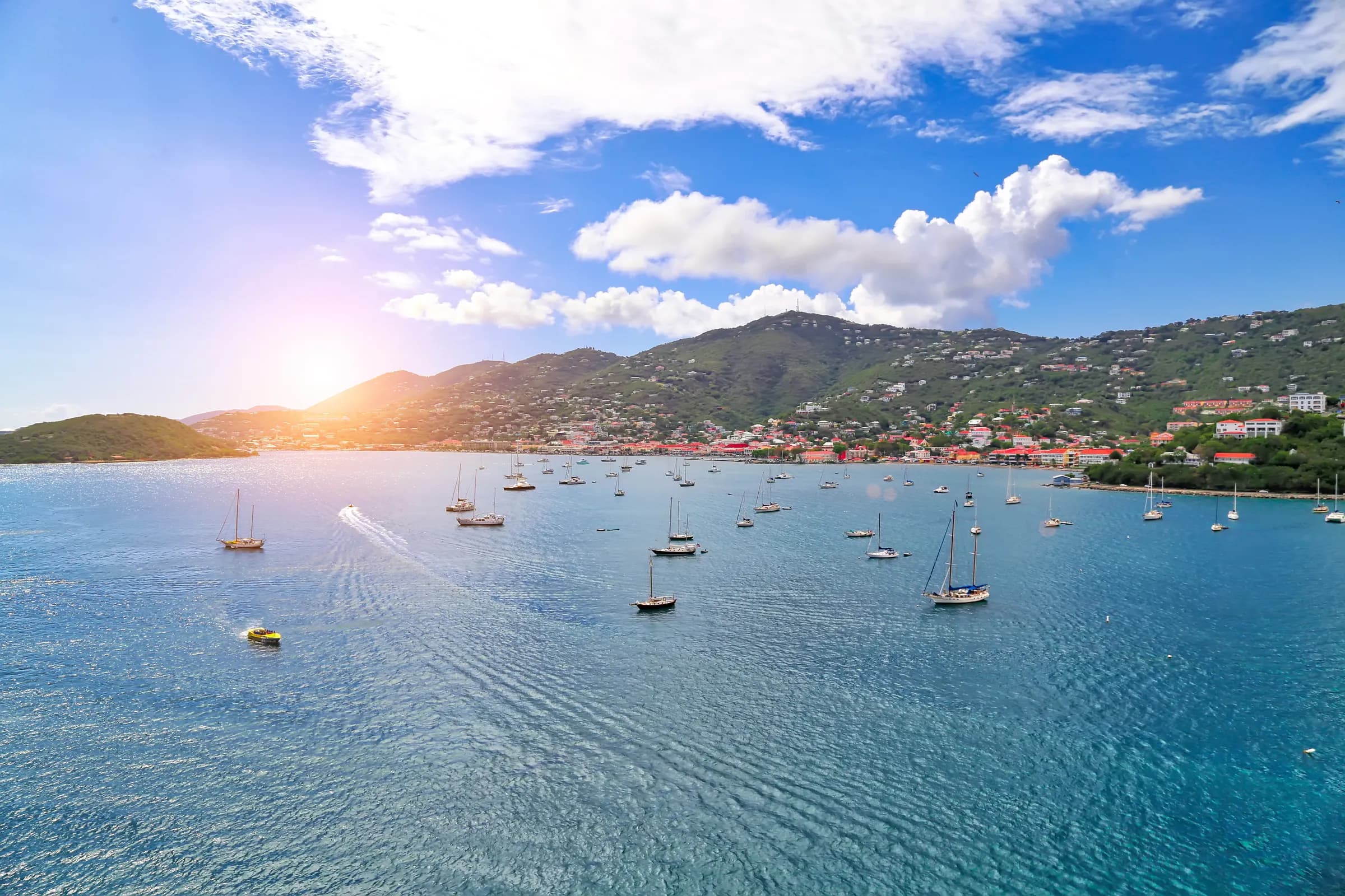 Sailboats anchored across Charlotte Amalie Bay on St. Thomas with green hills behind