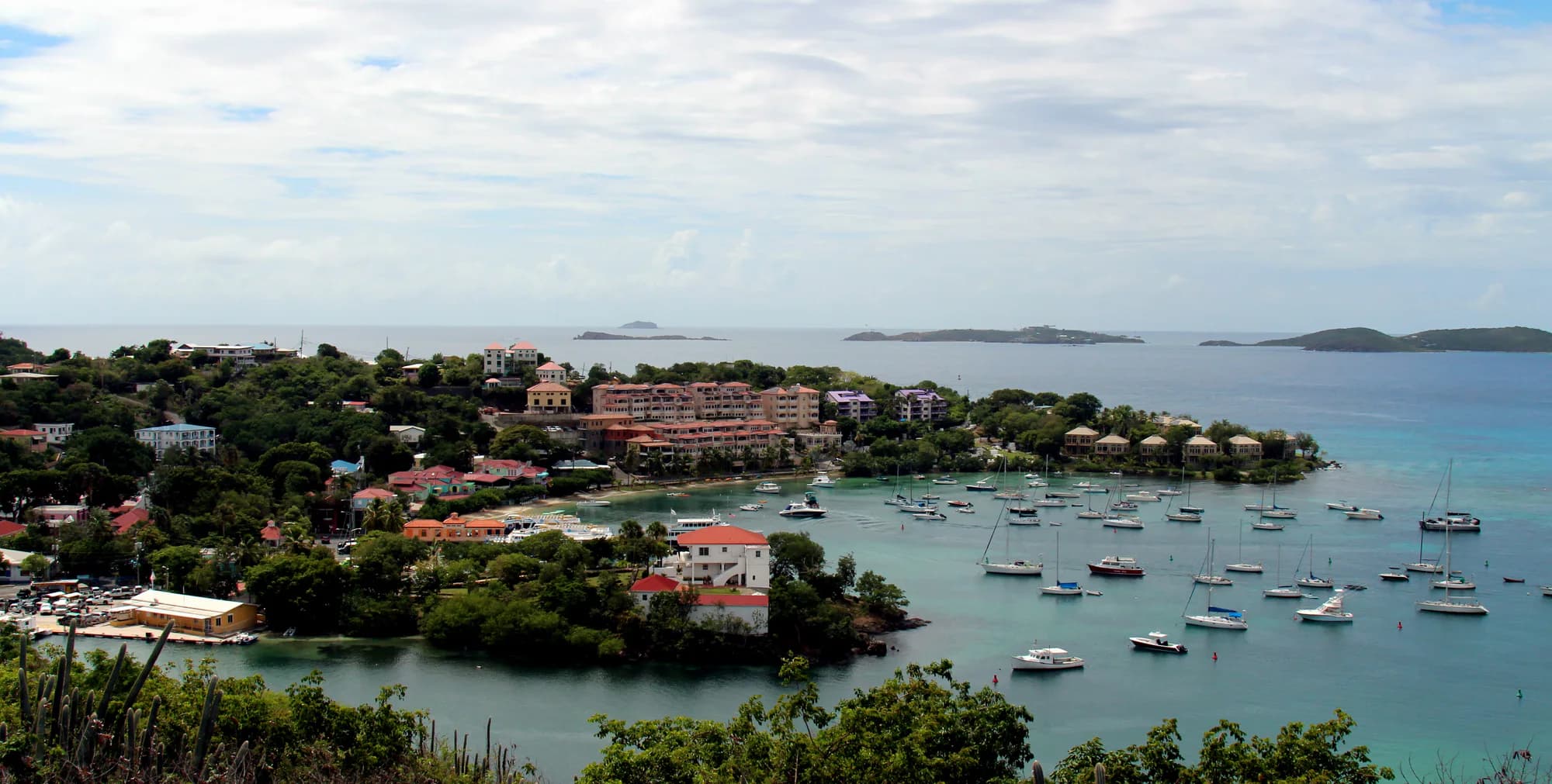 Wide view of Cruz Bay on St. John with boats, waterfront buildings, and green hills