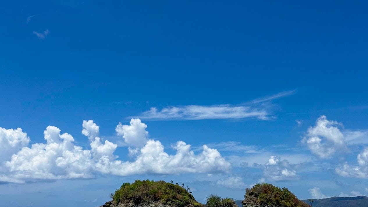 Trunk Cay and nearby rocky islets beneath bright clouds at Trunk Bay on St. John.